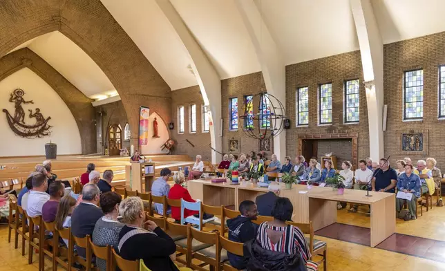 Laywoman Nancy Speeckaert, left, leads a service as parishioners sit at the Don Bosco church in Buizingen, Belgium, Sunday, Sept. 8, 2024. (AP Photo/Geert Vanden Wijngaert)