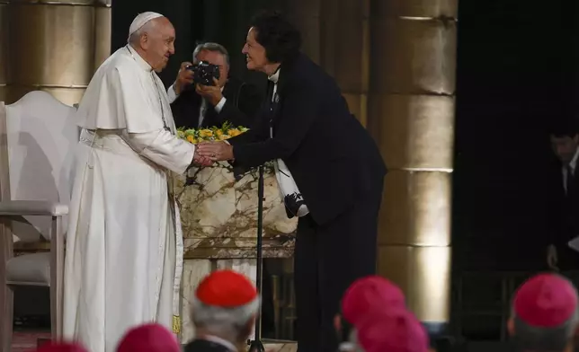 Pope Francis is greeted by Mia De Schamphelaere, coordinator of point of contact for victims of abuse, during a meeting with bishops, deacons, and religious people in Koekelberg Basilica of the Sacred Heart, in Koekelberg, Belgium, Saturday Sept. 28, 2024. (AP Photo/Omar Havana)