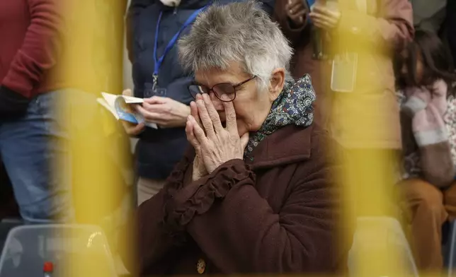 A faithful prays as Pope Francis presides the holy mass , at the King Baudouin stadium in Brussels, Belgium, Sunday, Sept. 29, 2024. (AP Photo/Omar Havana)