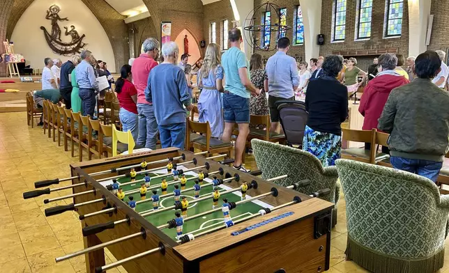 Parishioners stand together during a service at the Don Bosco Church in Buizingen, Belgium, Sunday, Sept. 1, 2024. (AP Photo/Raf Casert)