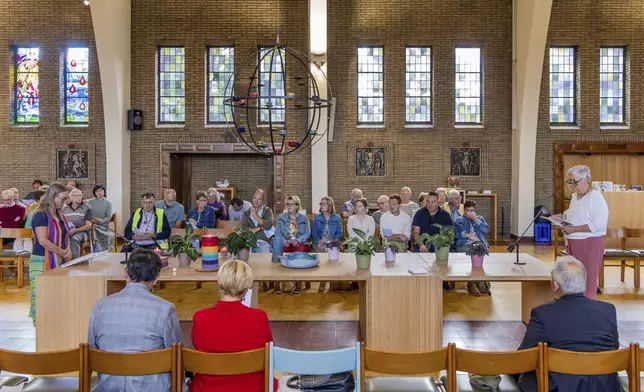 Laywomen Nancy Speeckaert, left, and Marijke Devaddere, right, lead a service as parishioners sit at the Don Bosco church in Buizingen, Belgium, Sunday, Sept. 8, 2024. (AP Photo/Geert Vanden Wijngaert)