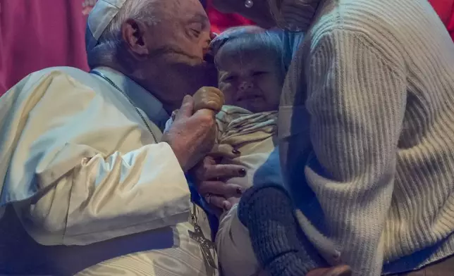 Pope Francis kisses a child during the Hope Happening youth festival at the Brussels Expo, Belgium, Saturday, Sept. 28, 2024, on the third day of his four-day visit to Luxembourg and Belgium. (AP Photo/Andrew Medichini)