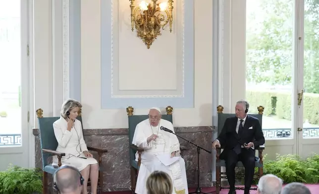 Pope Francis flanked by King Philippe and Queen Mathilde delivers his message during a meeting with the authorities and the civil society in the Grande Galerie of the Castle of Laeken, Brussels, Friday, Sept. 27, 2024. (AP Photo/Andrew Medichini)