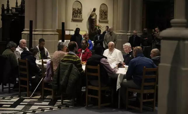 Pope Francis have a breakfast together with people who are experiencing homelessness and are assisted by the parish church of St. Gilles in Brussels, Saturday, Sept. 28, 2024. (AP Photo/Andrew Medichini)