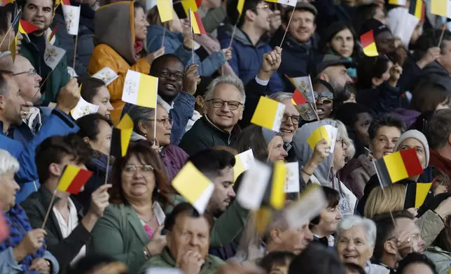 Faithful wave flags as Pope Francis arrives to lead the holy mass , at the King Baudouin stadium in Brussels, Belgium, Sunday, Sept. 29, 2024. (AP Photo/Omar Havana)