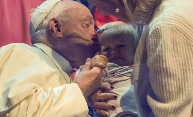 Pope Francis kisses a child during the Hope Happening youth festival at the Brussels Expo, Belgium, Saturday, Sept. 28, 2024, on the third day of his four-day visit to Luxembourg and Belgium. (AP Photo/Andrew Medichini)