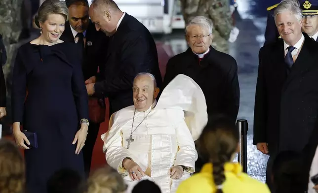 Pope Francis arrives flanked by Queen Mathilde of Belgium and King Philippe of Belgium, at Melsbroek air base in Steenokkerzeel, near Brussels, on the first day of his four-day visit to Luxembourg and Belgium, Thursday, Sept. 26, 2024. (AP Photo/Geert Vanden Wijngaert)