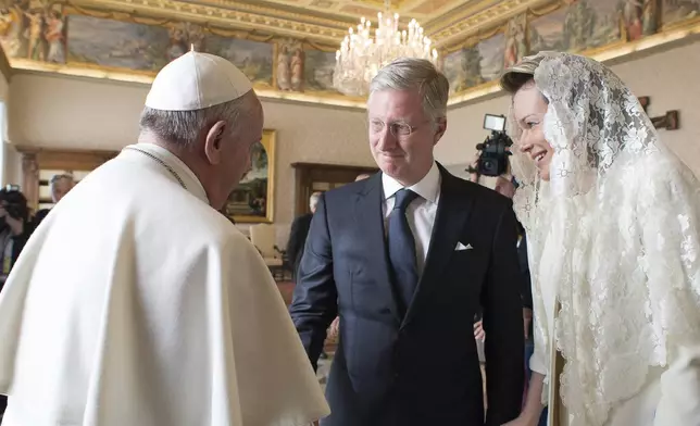 FILE — Pope Francis, left, greets Belgium's King Philippe, center, and Belgium's Queen Mathilde, at the end of a private audience at the Vatican, Monday, March 9, 2015. (AP Photo/Gabriel Bouys, Pool, File)