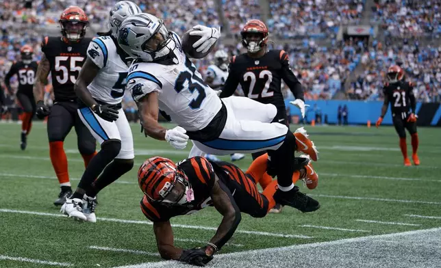 Carolina Panthers running back Chuba Hubbard is tackled by Cincinnati Bengals cornerback DJ Turner II during the first half of an NFL football game, Sunday, Sept. 29, 2024, in Charlotte, N.C. (AP Photo/Erik Verduzco)