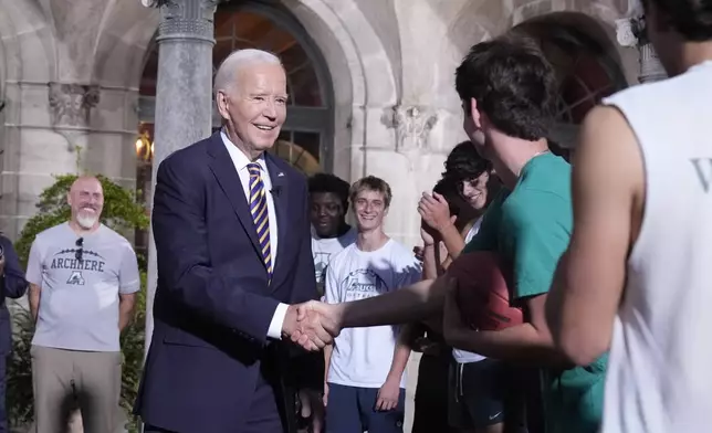 President Joe Biden's speaks with football players at Archmere Academy in Claymont, Del., Friday, Sept. 20, 2024, during a walkthrough visit ahead of his meetings with world leaders there on Saturday. (AP Photo/Mark Schiefelbein)