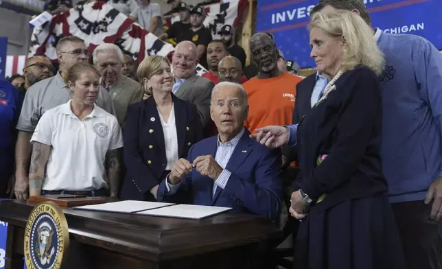 President Joe Biden speaks with Rep. Debbie Dingell, D-Mich., at a signing ceremony after speaking to labor union members about his Investing in America agenda during a visit to the U.A. Local 190 Training Center in Ann Arbor, Mich., Friday, Sep. 6, 2024. (AP Photo/Manuel Balce Ceneta)