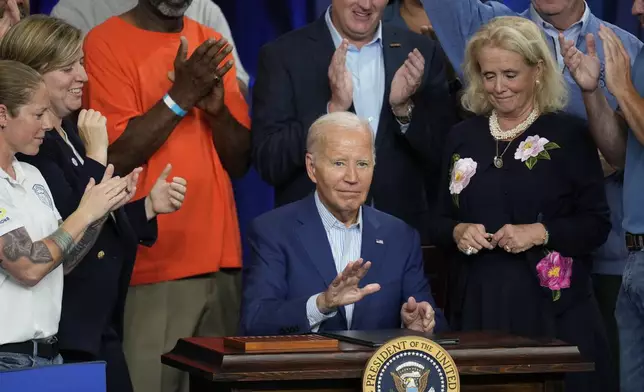 President Joe Biden signs an executive order for federal grants that would prioritize projects with labor agreements, wage standards and benefits such as access to child care and apprenticeship programs, during a visit to the U.A. Local 190 Training Center in Ann Arbor, Mich., Friday, Sept. 6, 2024. (AP Photo/Paul Sancya)