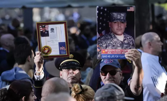 Attendees hold photos high during a ceremony marking the anniversary of the Sept. 11 terror attacks at the National September 11 Memorial &amp; Museum, Wednesday, Sept. 11, 2024, in New York. (AP Photo/Evan Vucci)