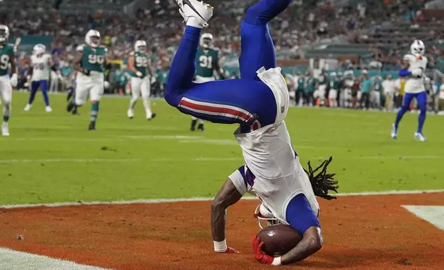 Buffalo Bills running back James Cook (4) holds onto the ball to score a touchdown during the first half of an NFL football game against the Miami Dolphins, Thursday, Sept. 12, 2024, in Miami Gardens, Fla. (AP Photo/Lynne Sladky)