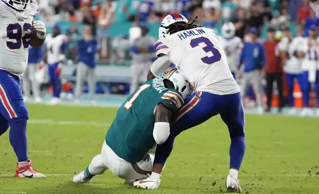 Miami Dolphins quarterback Tua Tagovailoa (1) collides with Buffalo Bills safety Damar Hamlin (3) during the second half of an NFL football game, Thursday, Sept. 12, 2024, in Miami Gardens, Fla. Tagovailoa was injured on the play. (AP Photo/Rebecca Blackwell)