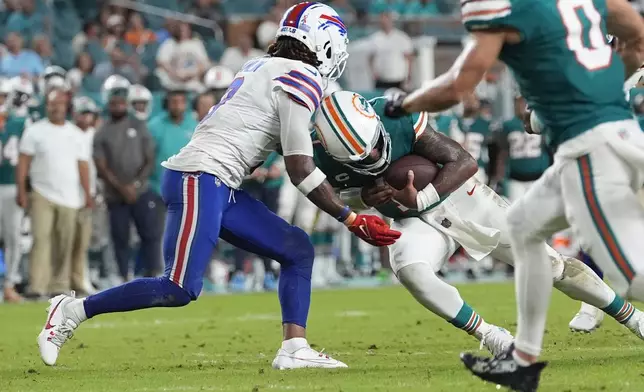 Miami Dolphins quarterback Tua Tagovailoa (1) and Buffalo Bills safety Damar Hamlin (3) collide during the second half of an NFL football game, Thursday, Sept. 12, 2024, in Miami Gardens, Fla. Tagovailoa suffered a concussion on the play. (AP Photo/Lynne Sladky)