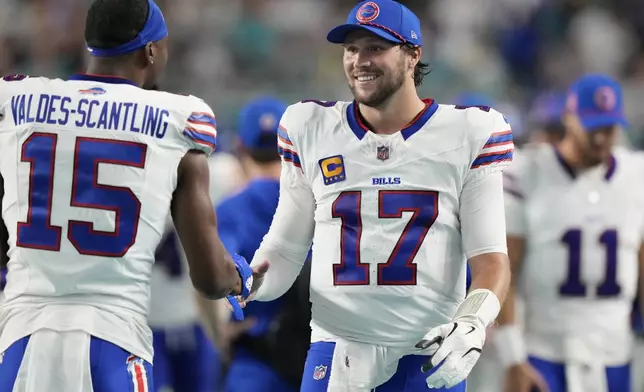 Buffalo Bills quarterback Josh Allen (17) and wide receiver Marquez Valdes-Scantling (15) shake hands during the second half of an NFL football game against the Miami Dolphins, Thursday, Sept. 12, 2024, in Miami Gardens, Fla. (AP Photo/Lynne Sladky)