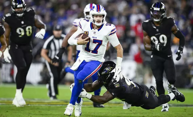 Buffalo Bills quarterback Josh Allen (17) runs with the ball as Baltimore Ravens defensive tackle Nnamdi Madubuike tries to stop him during the first half of an NFL football game, Sunday, Sept. 29, 2024, in Baltimore. (AP Photo/Nick Wass)