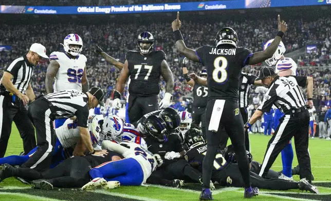 Baltimore Ravens quarterback Lamar Jackson (8) reacts as officials look through a pile of players to make a decision on a touchdown fumble recovery by Ravens' Patrick Ricard during the second half of an NFL football game against the Buffalo Bills, Sunday, Sept. 29, 2024, in Baltimore. (AP Photo/Nick Wass)