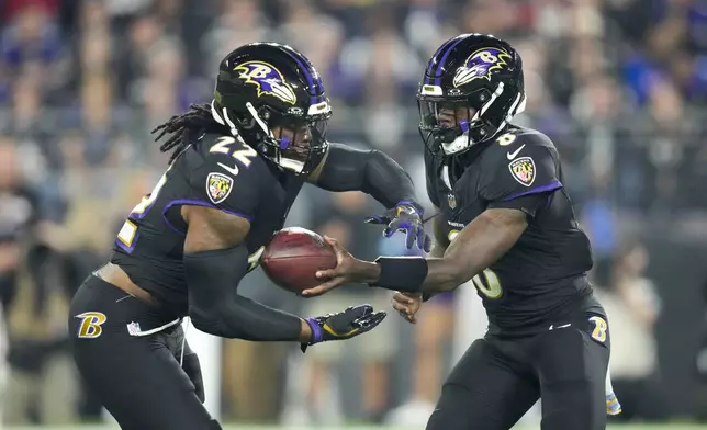 Baltimore Ravens running back Derrick Henry, left, takes a handoff from quarterback Lamar Jackson while running for a long touchdown against the Buffalo Bills during the first half of an NFL football game, Sunday, Sept. 29, 2024, in Baltimore. (AP Photo/Stephanie Scarbrough)