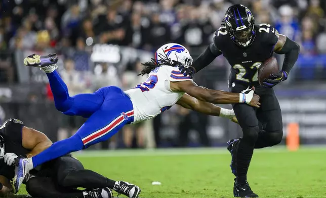 Baltimore Ravens running back Derrick Henry, right, runs with the ball as Buffalo Bills linebacker Dorian Williams tries to stop him during the first half of an NFL football game, Sunday, Sept. 29, 2024, in Baltimore. (AP Photo/Nick Wass)