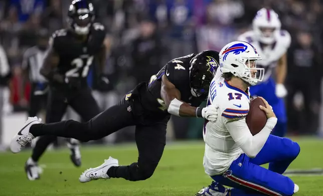 Buffalo Bills quarterback Josh Allen, right, takes a hit from Baltimore Ravens cornerback Marlon Humphrey during the first half of an NFL football game, Sunday, Sept. 29, 2024, in Baltimore. (AP Photo/Nick Wass)