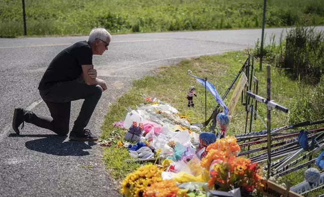 Richie Mathers, an assistant coach on a youth team that Johnny Gaudreau played for, visits the memorial for brothers Johnny and Matthew Gaudreau, who died last week when they were struck by a suspected drunken driver while riding bicycles, in Salem County, N.J, Wednesday, Sept. 4, 2024. (Jessica Griffin/The Philadelphia Inquirer via AP)