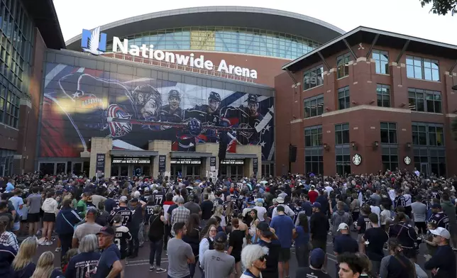 Fans gather for a candlelight vigil to honor Columbus Blue Jackets hockey player Johnny Gaudreau, outside of Nationwide Arena in Columbus, Ohio, Thursday, Sept. 4, 2024. Gaudreau and his brother Matthew were killed by a motor vehicle last week while riding bicycles. (AP Photo/Joe Maiorana)