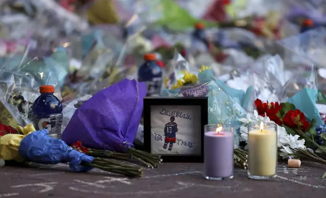 Fans leave mementos as part of the candlelight vigil to honor Columbus Blue Jackets hockey player Johnny Gaudreau, Thursday, Sept. 4, 2024, outside of Nationwide Arena in Columbus, Ohio. Gaudreau and his brother Matthew were killed by a motor vehicle last week while riding bicycles. (AP Photo/Joe Maiorana)