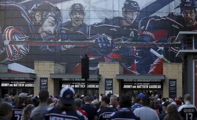 Fans gather for a candlelight vigil to honor Columbus Blue Jackets hockey player Johnny Gaudreau, Thursday, Sept. 4, 2024, outside of Nationwide Arena in Columbus, Ohio. Gaudreau and his brother Matthew were killed by a motor vehicle last week while riding bicycles. (AP Photo/Joe Maiorana)