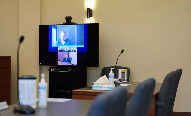 Sean M. Higgins, top, the alleged drunken driver charged with killing NHL hockey player Johnny Gaudreau and his brother Matthew as they bicycled on a rural road, appears before Judge Michael Silvanio, bottom, for his hearing via video from jail, Friday, Sept. 13, 2024, in Woodbury, N.J. (AP Photo/Derik Hamilton)