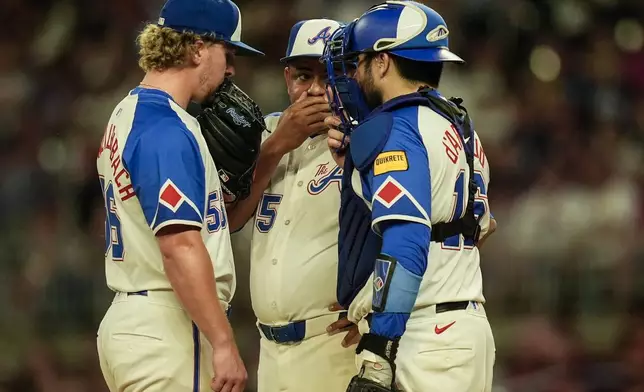 Atlanta Braves pitcher Spencer Schwellenbach (56) speaks with bullpen coach Erick Abreu (85) and catcher Travis d'Arnaud (16) on the mound in the fourth inning of a baseball game against the Toronto Blue Jays, Saturday, Sept. 7, 2024, in Atlanta.(AP Photo/Mike Stewart)