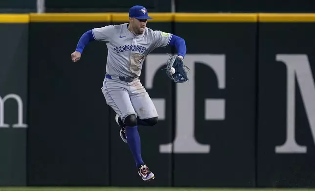 Toronto Blue Jays right fielder George Springer grabs a two-run single by Texas Rangers' Adolis Garcia in the fourth inning of a baseball game in Arlington, Texas, Tuesday, Sept. 17, 2024. (AP Photo/Tony Gutierrez)