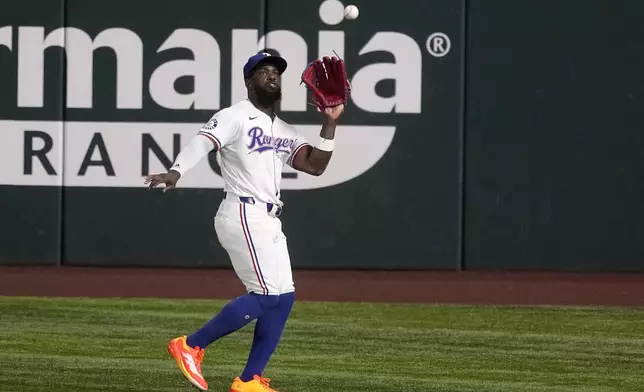 Texas Rangers right fielder Adolis Garcia settles beneath a Toronto Blue Jays' Vladimir Guerrero Jr. fly out in the first inning of a baseball game in Arlington, Texas, Wednesday, Sept. 18, 2024. (AP Photo/Tony Gutierrez)