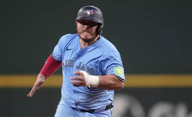 Toronto Blue Jays' Alejandro Kirk advances to third on a double by Spencer Horwitz in the fifth inning of a baseball game against the Texas Rangers in Arlington, Texas, Wednesday, Sept. 18, 2024. (AP Photo/Tony Gutierrez)