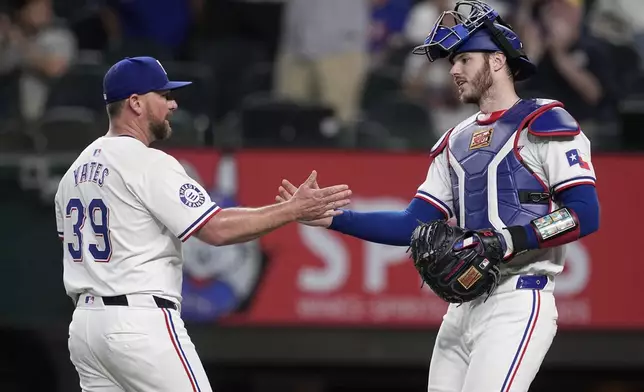 Texas Rangers' Kirby Yates (39) and Jonah Heim, right, celebrate the team's win against the Toronto Blue Jays in a baseball game in Arlington, Texas, Tuesday, Sept. 17, 2024. (AP Photo/Tony Gutierrez)