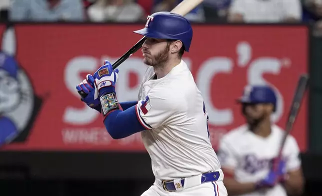 Texas Rangers' Jonah Heim follows through on a two-run single against the Toronto Blue Jays in the sixth inning of a baseball game in Arlington, Texas, Tuesday, Sept. 17, 2024. (AP Photo/Tony Gutierrez)