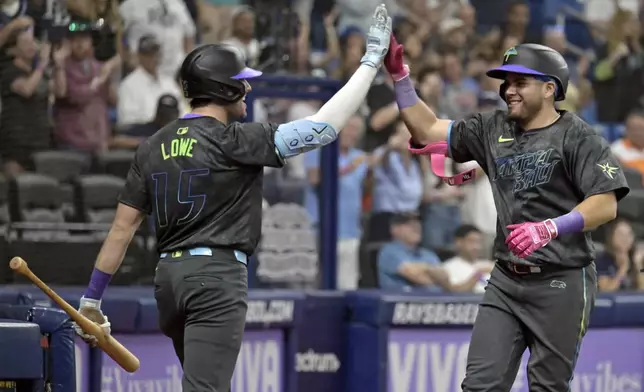 Tampa Bay Rays' Josh Lowe (15) congratulates Jonathan Aranda, right, after Aranda's two-run home run off Toronto Blue Jays starter Yariel Rodríguez during the third inning of a baseball game Saturday, Sept. 21, 2024, in St. Petersburg, Fla. (AP Photo/Steve Nesius)