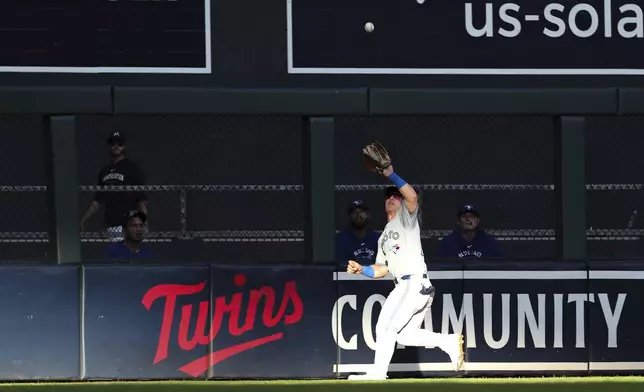 Toronto Blue Jays center fielder Daulton Varsho catches a fly ball hit by Minnesota Twins designated hitter Trevor Larnach during the first inning of a baseball game, Saturday, Aug. 31, 2024, in Minneapolis. (AP Photo/Matt Krohn)