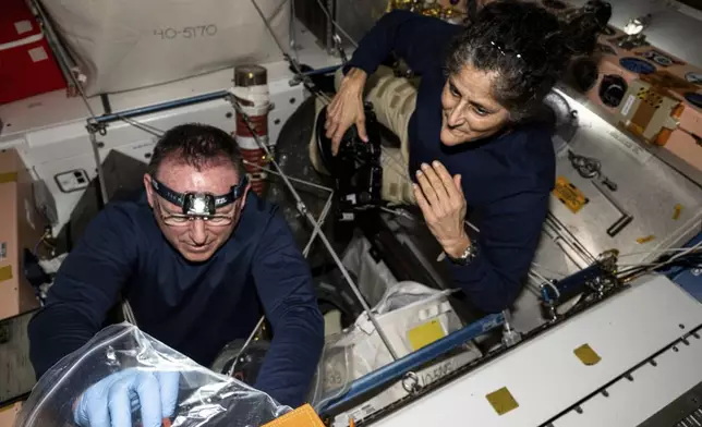 In this photo provided by NASA, astronauts Butch Wilmore, left, and Suni Williams inspect safety hardware aboard the International Space Station on Aug. 9, 2024. (NASA via AP)