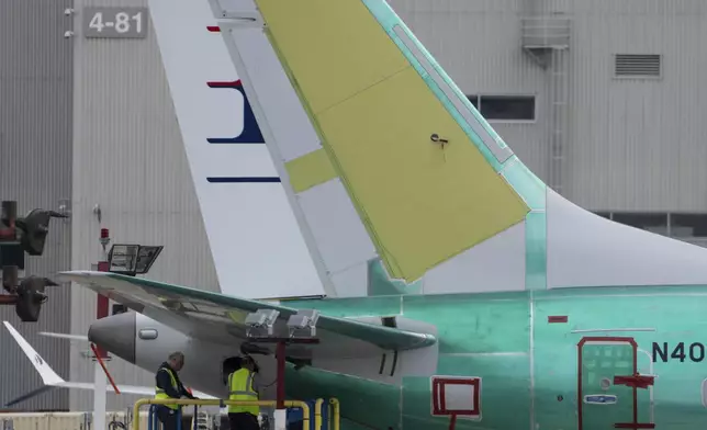 Workers check out the tail section of a Boeing 737 MAX airliner at the company's factory on Thursday, Sept. 12, 2024, in Renton, Wash. (AP Photo/Stephen Brashear)