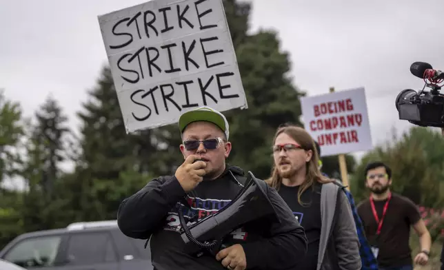 International Aerospace Machinists union members march toward the union's hall to vote on a contract offer with airplane maker Boeing, on Thursday, Sept. 12, 2024, in Renton, Wash. (AP Photo/Stephen Brashear)