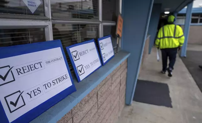 Signs encouraging International Aerospace Machinists union members to vote no on a contract offer with airplane maker Boeing, are pictured at the union's hall, on Thursday, Sept. 12, 2024, in Renton, Wash. (AP Photo/Stephen Brashear)