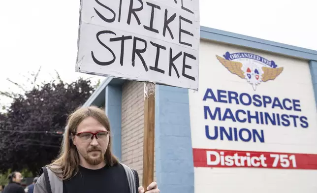 An International Aerospace Machinists union member holds a sign encouraging a strike as fellow union members negotiate a contract offer with airplane maker Boeing, on Thursday, Sept. 12, 2024, in Renton, Wash. (AP Photo/Stephen Brashear)