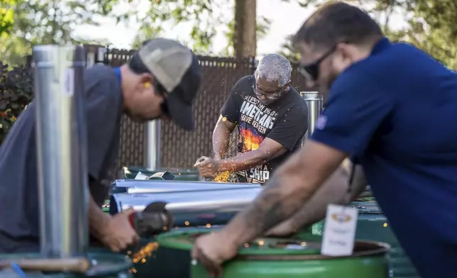 International Aerospace Machinists member Clint Moore, center, builds burn barrels with fellow union members in preparation for strike if members recject a contract offer by airplane maker Boeing, on Thursday, Sept. 12, 2024, in Seattle. (AP Photo/Stephen Brashear)