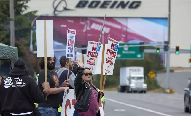 Boeing Machinists Union member Stephanie Corona waves to passing traffic while on the picket line at the Everett plant, Friday, Sept. 13, 2024, in Everett, Wash. (AP Photo/John Froschauer)