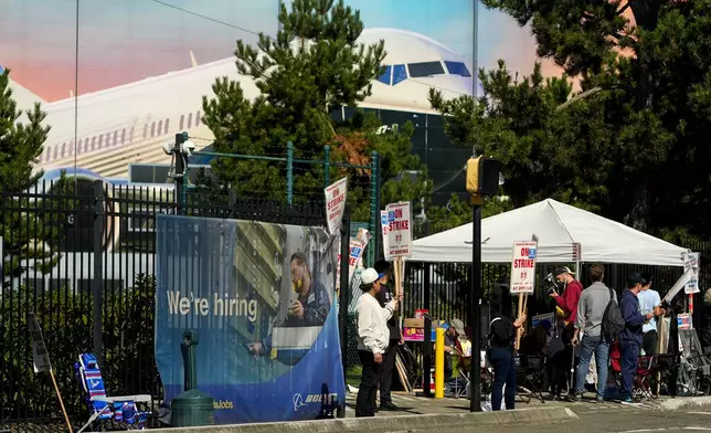 Boeing workers hold picket signs as they strike Tuesday, Sept. 24, 2024, outside the company's factory in Renton, Wash. (AP Photo/Lindsey Wasson)