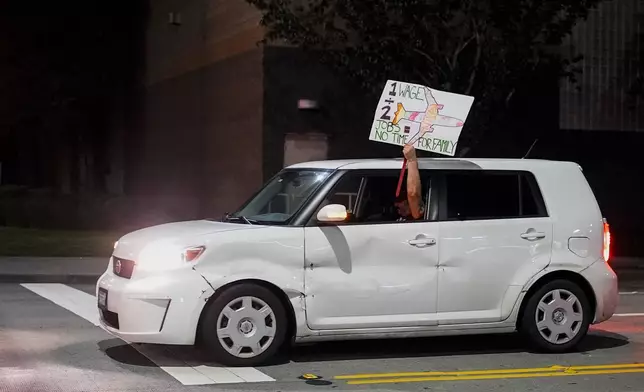 A driver holds a sign out their window as they drive by Boeing workers picketing after union members voted overwhelmingly to reject a contract offer and go on strike Friday, Sept. 13, 2024, outside the company's factory in Renton, Wash. (AP Photo/Lindsey Wasson)