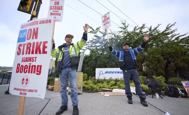 Boeing Machinists Union members Dave Hendrickson, left, and Steven Wilson, right, on the picket line at the Renton assembly plant, Friday, Sept. 13, 2024, in Renton, Wash. (AP Photo/John Froschauer)