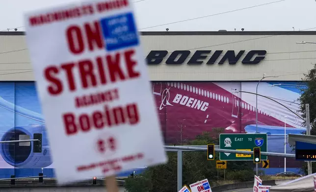 Boeing workers wave picket signs as they strike after union members voted to reject a contract offer, Sunday, Sept. 15, 2024, near the company's factory in Everett, Wash. (AP Photo/Lindsey Wasson)